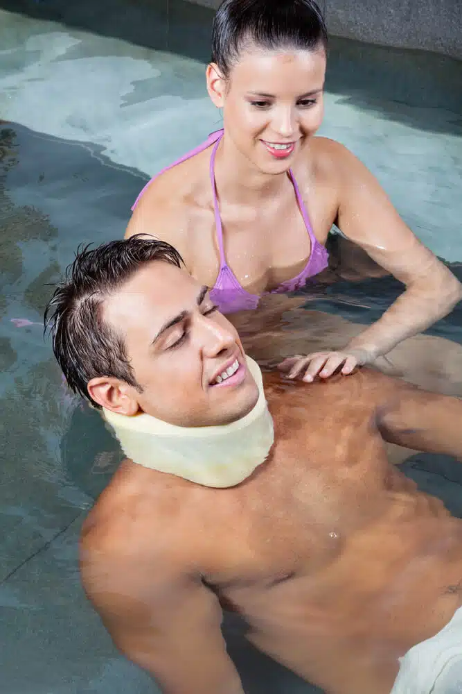 a man getting aquatic therapy from a woman