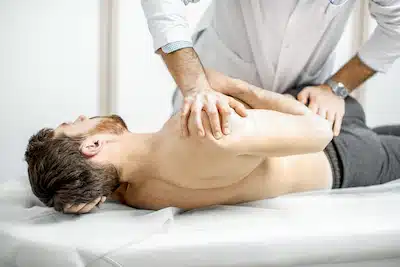 chiropractic care by making spinal adjustment to a male patient
