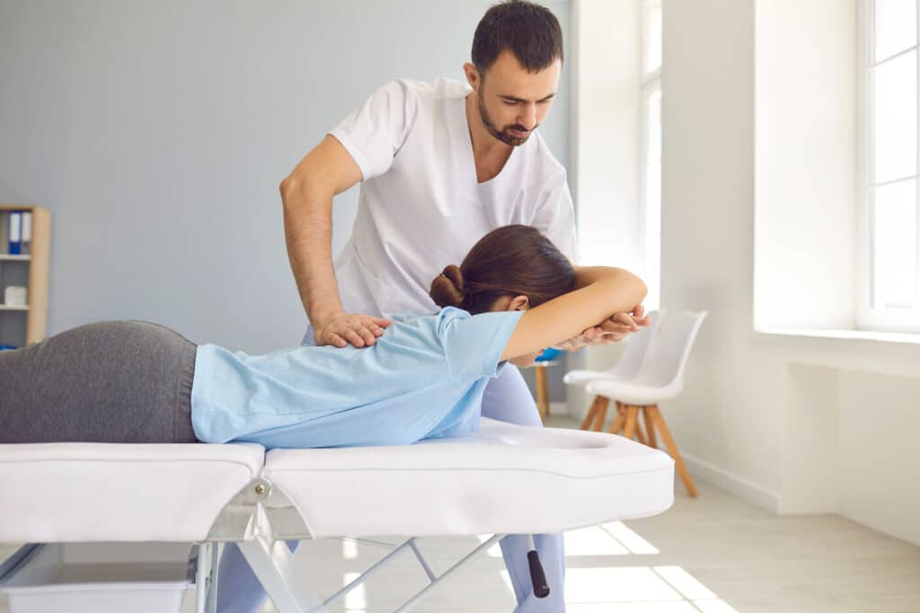 Woman having chiropractic back adjustment