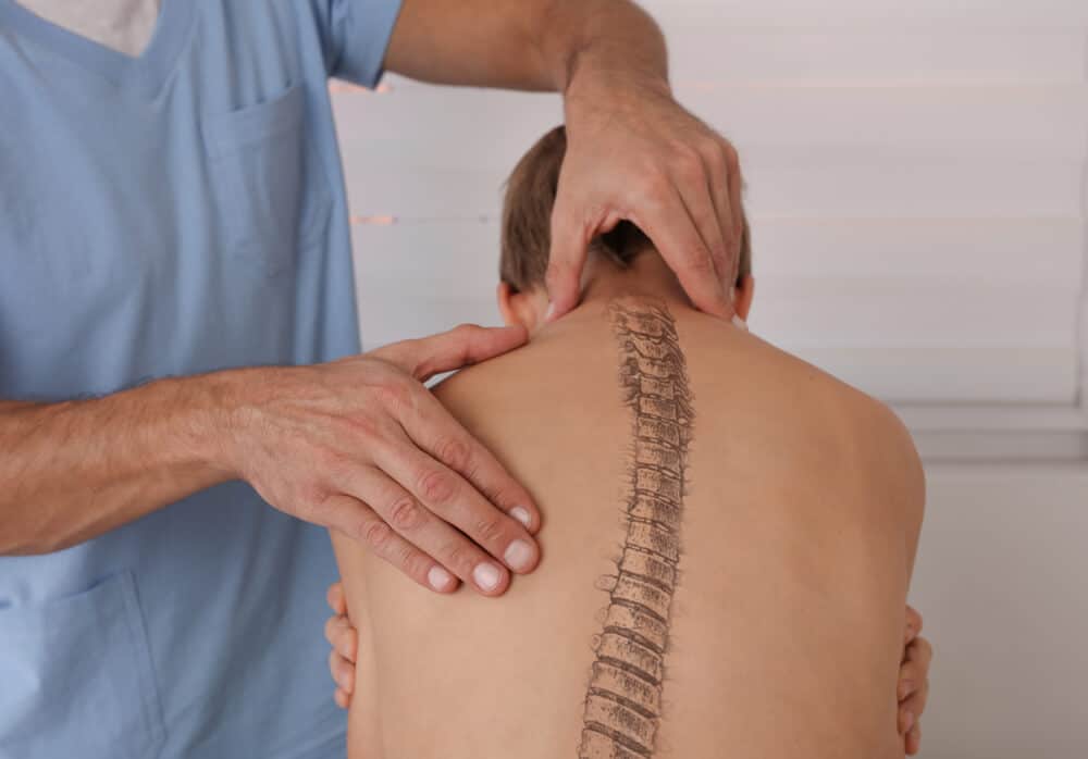A child receiving scoliosis examination from a doctor