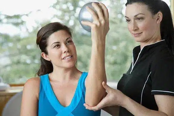 Physical therapist guiding a patient through a controlled arm exercise to improve mobility and strength.