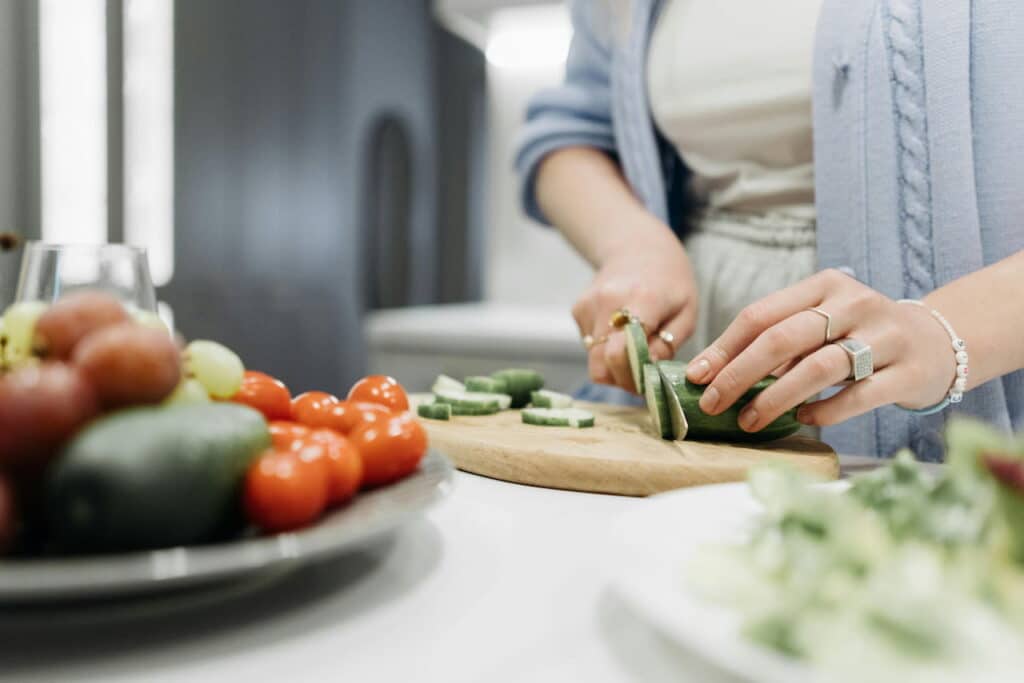 Person Slicing Cucumber for Lifestyle Strategies That Support Joint Health